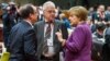 German Chancellor Angela Merkel, rigth, speaks with French President Francois Hollande, far left, at EU summit, Brussels, Mar. 15, 2013.