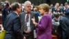 German Chancellor Angela Merkel (R) speaks with French President Francois Hollande (L) during a round table meeting at an EU summit in Brussels, March 15, 2013.