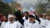 FILE - Thousands of civil servants and members of Turkish unions wear placards that read "no to corruption" as they march to protest against the government's new labor regulations and economy policies in Ankara, April 4, 2015. 