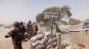 FILE - Cameroon soldiers stand guard at a lookout post as they take part in operations against the Islamic extremists group Boko Haram, their guard post is on Elbeid bridge, left rear, that separates northern Cameroon form Nigeria's Borno state.