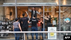 Punonjësit heqin xhamat e thyer në një dyqan që u plaçkit gjatë natës së katërt të protestave në Francë, që shpërthyen pas vdekjes së një adoleshenti që u qëllua nga policia. Lion, Francë, 1 korrik, 2023.
