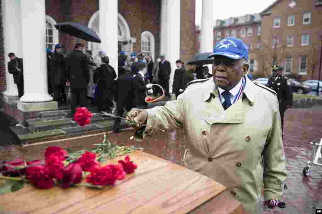 Tuskegee Airman Eugene J. Richardson Jr., places a flower on the casket containing the remains of his comrade John L. Harrison, Jr., after Harrison's a funeral mass in Philadelphia. Harrison Jr. became one of America's first black military airmen, one of nearly 1,000 pilots who trained as a segregated unit with the Army Air Forces at an airfield near Tuskegee, Alabama.