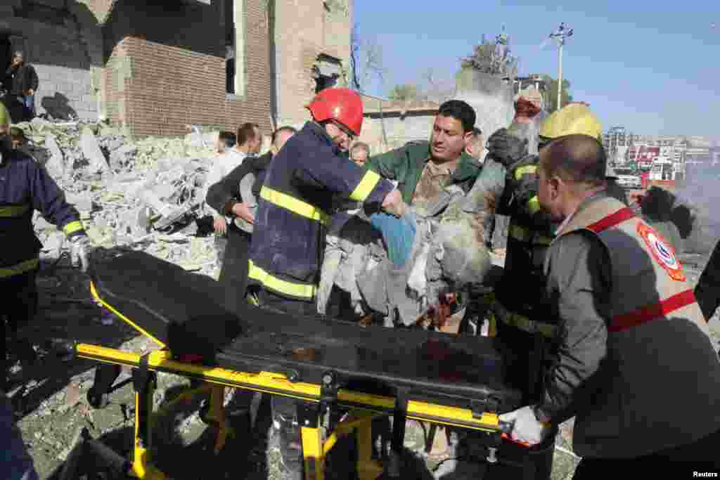 Medical personnel carry a victim to a stretcher at the site of a suicide bomb attack in Kirkuk, Iraq, Feb. 3, 2013. 