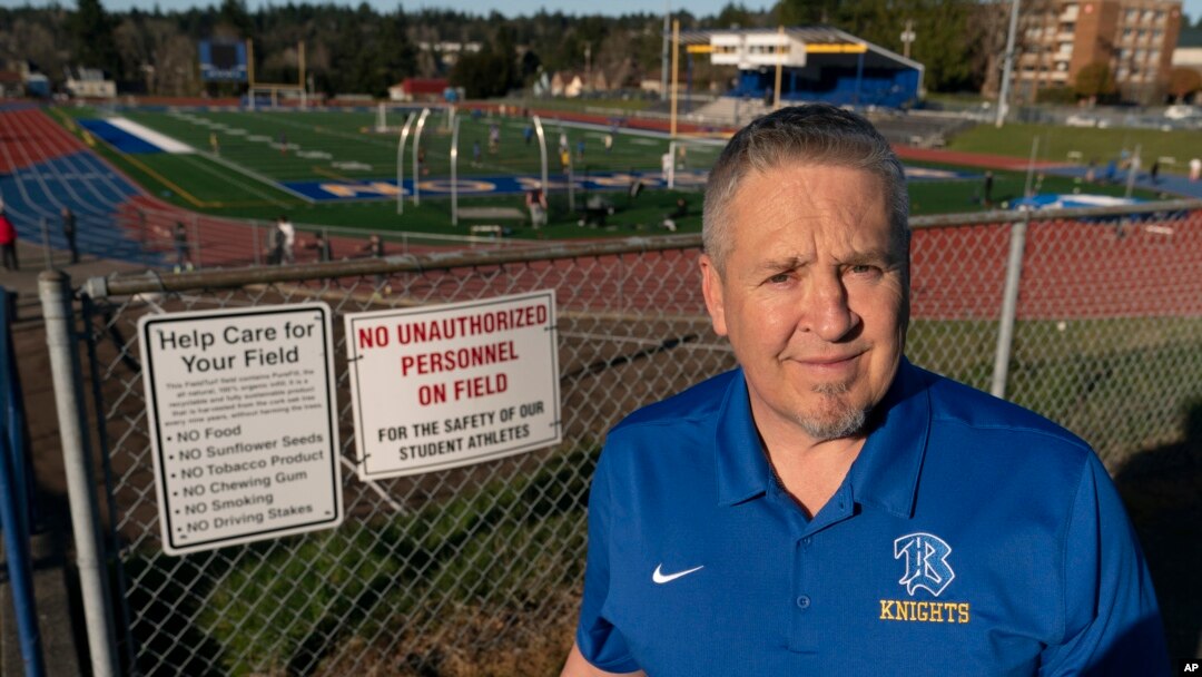 Joe Kennedy, a former assistant football coach at Bremerton High School in Bremerton, Wash., poses for a photo March 9, 2022, at the school's football field. (AP Photo/Ted S. Warren)