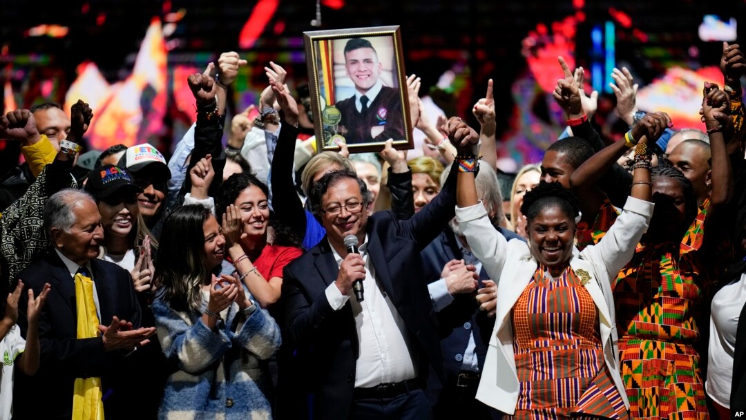 Presidential candidate Gustavo Petro, center, holds up the arm of running mate Francia Marquez on election night in Bogota, Colombia, Sunday, May 29, 2022. Marquez is making history as the country's first Black vice president. 