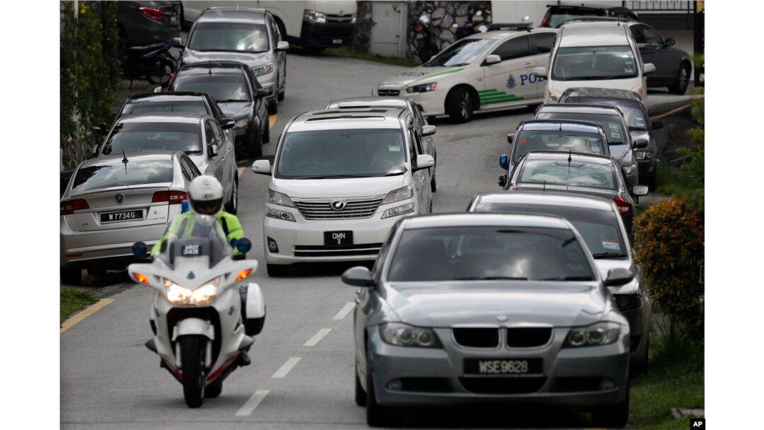 A car, center, believed to be carrying former Malaysian Prime Minister Najib Razak leaves his private resident in Kuala Lumpur, Malaysia, May 18, 2018. Malaysian police confiscated a few hundred designer handbags and dozens of suitcases containing cash, jewelry and other valuables as part of a corruption and money-laundering investigation into Najib.