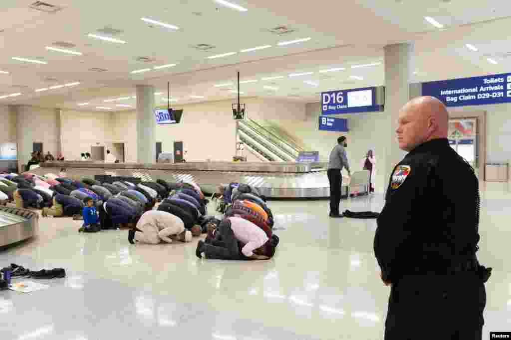 People gather to pray in baggage claim during a protest against the travel ban imposed by U.S. President Donald Trump's executive order, at Dallas/Fort Worth International Airport in Dallas, Texas, Jan. 29, 2017.