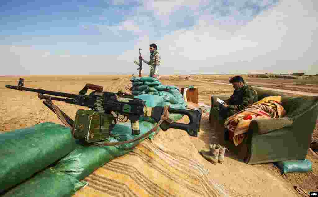 Fighters of the Hashed al-Shaabi paramilitaries stand guard by defensive positions near the frontline village of Shar'iah, on the outskirts of Tal Afar west of Mosul.