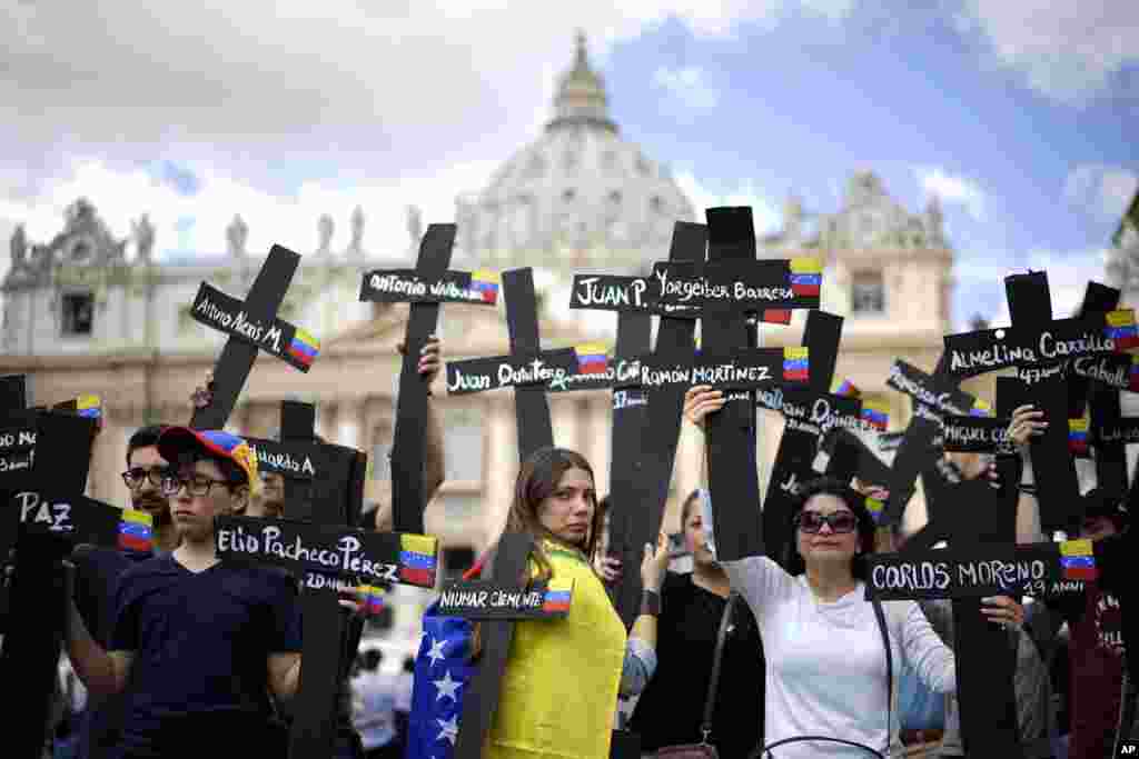 Demonstrators hold black crosses adorned with Venezuela flags and with the names of those who were killed in weeks of violent demonstrations calling on Venezuela&#39;s President Nicolas Maduro to step down, stage a demonstration in St. Peter&#39;s Square at the Vatican.