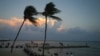 Gente en la playa mientras se pone el sol antes de la llegada del huracán Beryl en Playa del Carmen, México, el miércoles 3 de julio de 2024. 