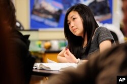 FILE - Sally Kim takes notes during a class in Columbia, Mo. The Common Core approach to math has its critics, who say the method only complicates the subject.