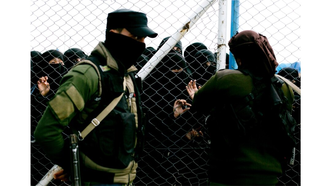FILE - Women speak to guards at the gate that closes off a section for foreign families who lived in the Islamic State's so-called caliphate, at al-Hol camp, in Hasaka province, Syria, March 31, 2019.