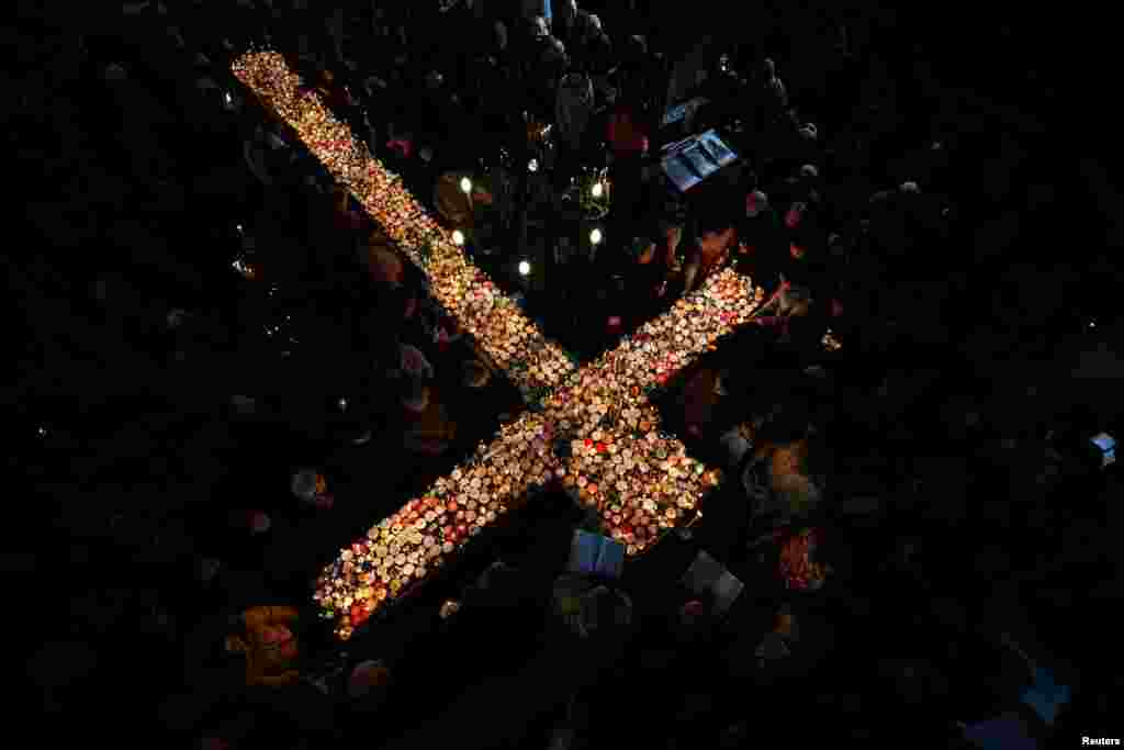 Worshippers gather around candles stuck in jars with honey, during a religious mass on the day of Saint Haralampi, the Orthodox patron saint of beekeepers, in the church of the Presentation of the Blessed Virgin in Blagoevgrad, Bulgaria.