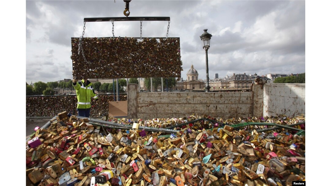 City municipal employees lower iron grills covered with "love locks" into a truck after they were removed from the Pont des Arts in Paris, June 1, 2015.