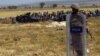 Turkish soldiers stand as people from the Syrian town of Kobani wait to cross into Turkey following the attacks by Islamic State militants as seen from the Turkish side of the border in Suruc, Turkey, June 25, 2015. 