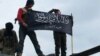 FILE - Rebels from al-Qaida-affiliated Jabhat al-Nusra wave their brigade flag as they stand atop a Syrian air force helicopter at Taftanaz air base, Jan. 11, 2013.