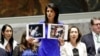FILE - U.S. Ambassador to the United Nations Nikki Haley shows pictures of Syrian victims of chemical attacks as she addresses a meeting of the Security Council on Syria at U.N. headquarters, in New York, April 5, 2017. 