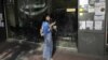 A woman smokes a cigarette outside an unemployment bureau in Athens, October 11, 2012.