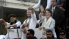 India's Congress party President Rahul Gandhi, center, gestures with the party's general secretaries Priyanka Gandhi Vadra, right, and Jyotiraditya Scindia, left, by his side during a rally in Lucknow, India, Feb. 11, 2019.