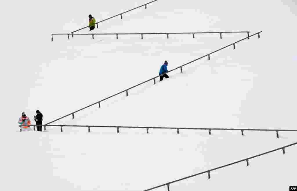 People walk on a snowy stairs of the Garmisch-Partenkirchen hill before the qualification jump of the second session of the Four-Hills Ski jumping tournament (Vierschanzentournee) in Garmisch-Partenkirchen, southern Germany.