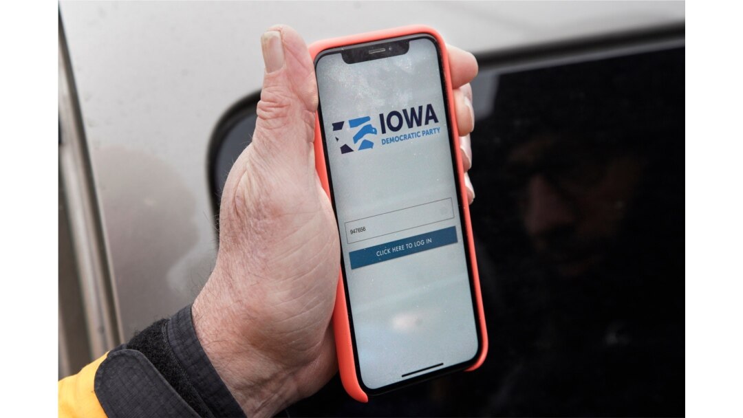 Precinct captain Carl Voss of Des Moines displays the Iowa Democratic Party caucus reporting app on his phone outside of the Iowa Democratic Party headquarters in Des Moines, Iowa, Feb. 4, 2020.