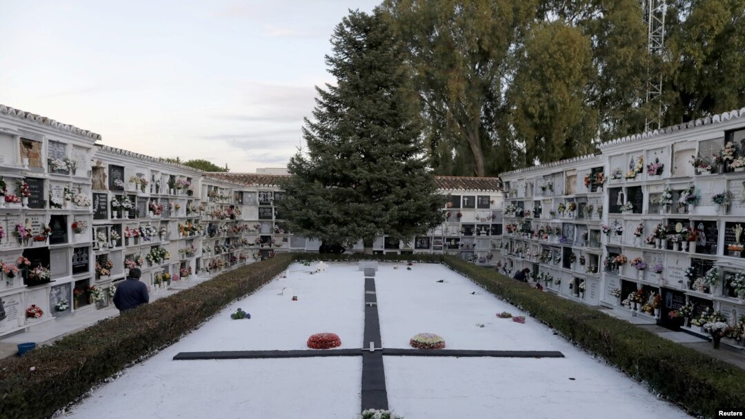 FILE - A man walks past a big tombstone commemorating those who died during the Spanish Civil War, at a cemetery ahead of All Saints Day, in Ronda, Spain, Oct. 28, 2020. 