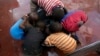 Kids scrape for remaining rice inside a pot at a displacement center in Beira, Mozambique, March 22, 2019. 