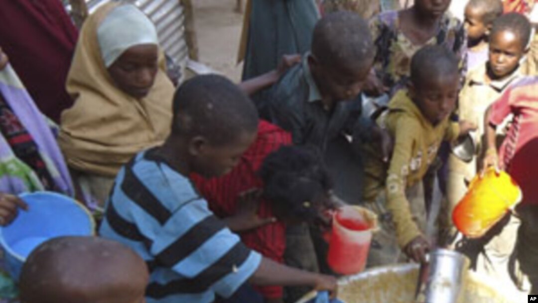 Children from southern Somalia get cooked food at a local NGO's compound in Mogadishu, Somalia, September 14, 2011.