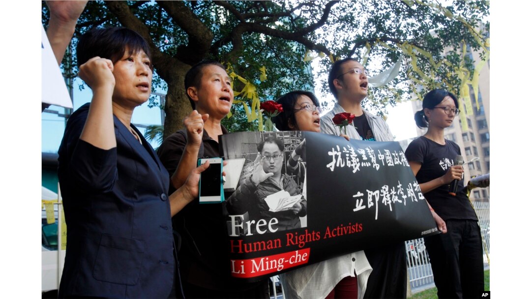 Supporters of Taiwanese activist Lee Ming-che detained in China, chant their support during a media event in Taipei, Taiwan, Nov. 28, 2017.