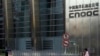 FILE - A woman walks past the entrance of the headquarters of China National Offshore Oil Corp (CNOOC) in Beijing, Sept. 23, 2010.