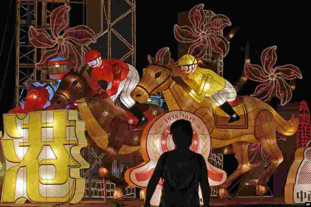 A woman stands in front of the lantern decorations that are displayed to mark the 20th anniversary of Hong Kong's handover to Chinese rule, in Hong Kong.