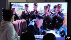 People watches a television screen showing a file image of North Korean leader Kim Jong Un during a news program at the Seoul Railway Station in Seoul, South Korea, March 21, 2020. 