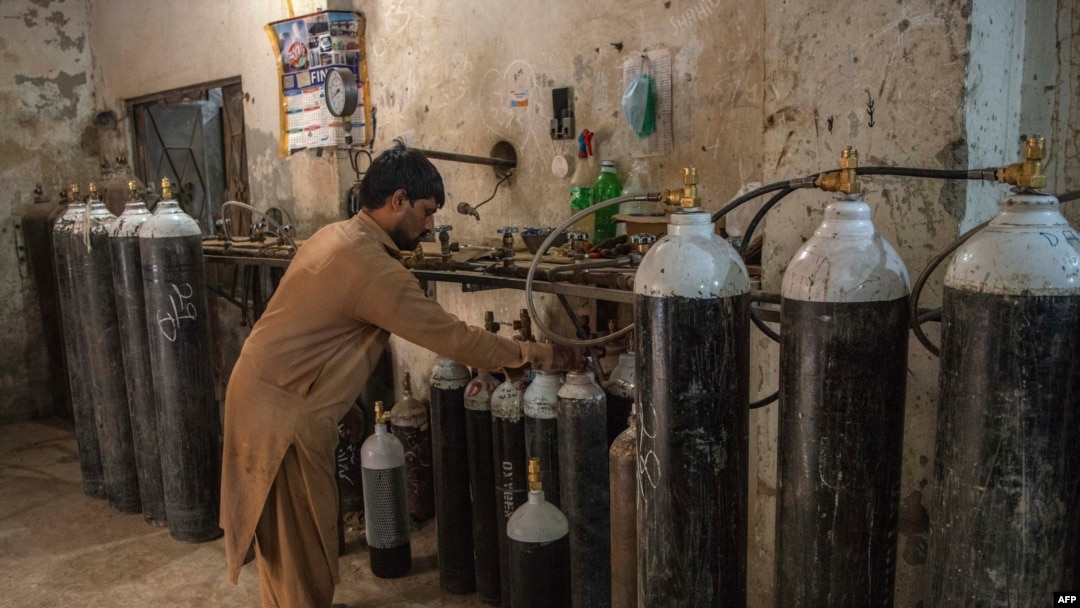 A worker fills oxygen tanks for use in hospitals in Peshawar, Pakistan, Dec. 7, 2020.