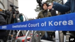 FILE - Members of the media wait for witnesses to arrive for the hearing in the impeachment trial of President Park Geun-hye at the Constitutional Court in Seoul, South Korea, Jan. 5, 2017.