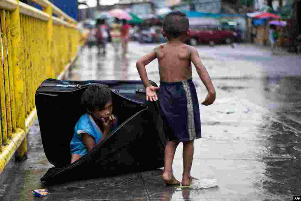  A boy hides in a suitcase at the Divisoria market in Manila, the Philippines.