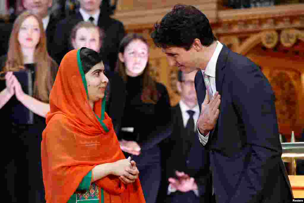 Canada's Prime Minister Justin Trudeau (R) gestures toward Pakistani Nobel Peace Prize laureate Malala Yousafzai after presenting her with honorary Canadian citizenship during a ceremony in the Library of Parliament on Parliament Hill in Ottawa, Ontario.