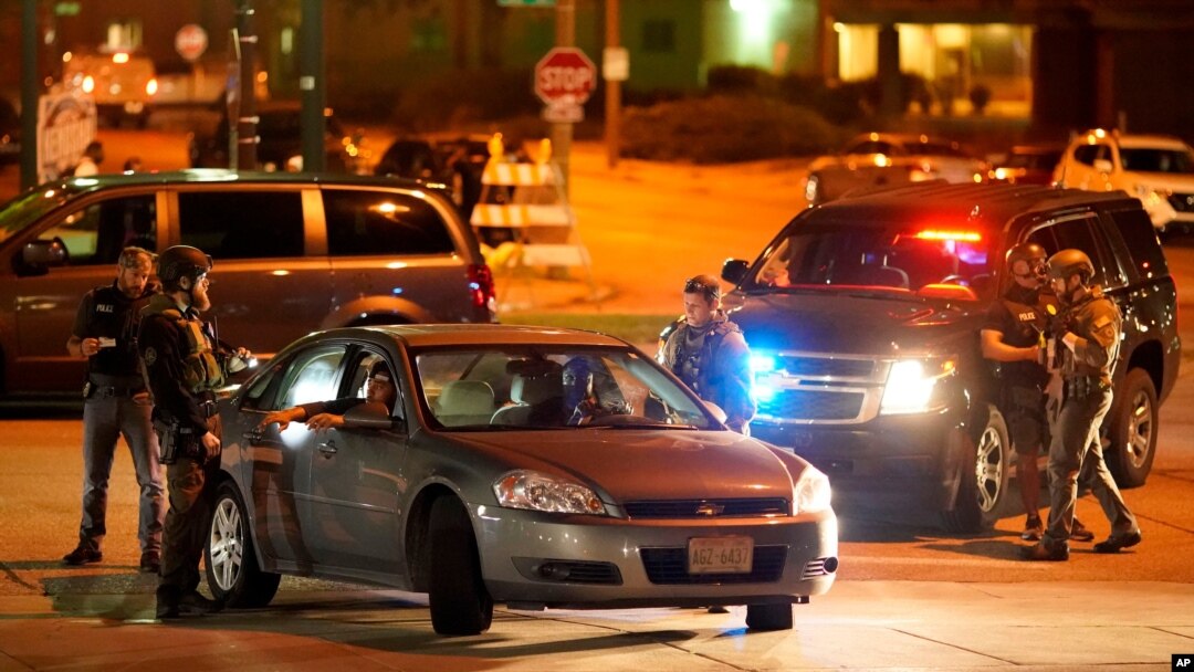 Police stop a car near where protesters gather for a fourth night to demonstrate against the police shooting of Jacob Blake in Kenosha, Wis., Aug. 26, 2020.