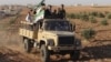 Free Syrian Army fighters with opposition flags ride a truck, which they say was captured from the Syrian army loyal to President Bashar al-Assad, in Saraqeb near Idlib, October 15, 2012. 