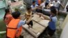 Rescuers move children to an evacuation center at Malabon city, north of Manila, Philippines, Aug. 1, 2012.
