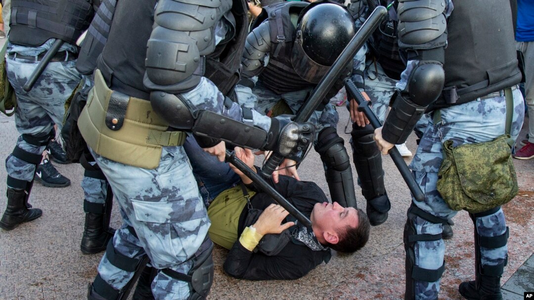 FILE - Police officers detain a person during an unsanctioned rally in Moscow, July 27, 2019.