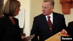 Hungary's President Pal Schmitt shows a special edition of the new constitution to Zsuzsanna Miko (L), director of the National Archives of Hungary, in Budapest, Jan. 5, 2012. 