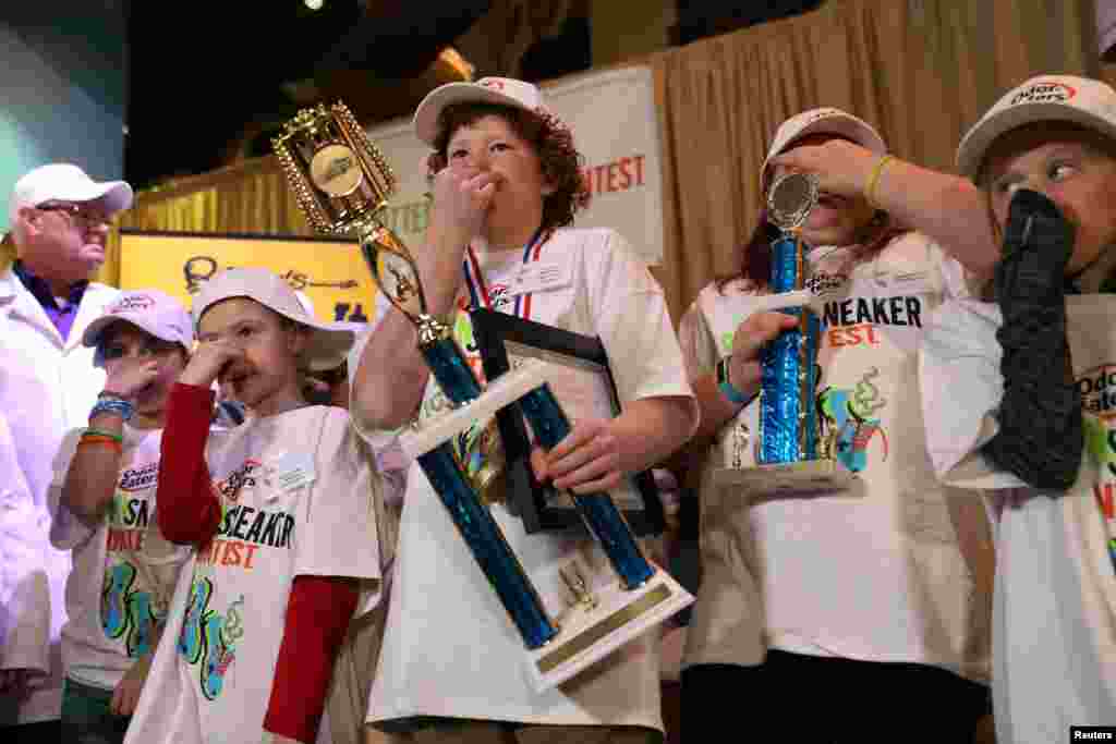 Connor Slocombe, from Eagle River, Alaska, holds his trophy with other contestants after winning Odor-Eater's Rotten Sneaker Contest at Ripley's Believe It or Not! in Times Square in New York.