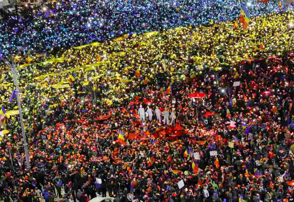 People light the flashes of their mobile phones in the colors of Romania's flag during an anti-government protest in Bucharest, Romania, Feb. 12, 2017.