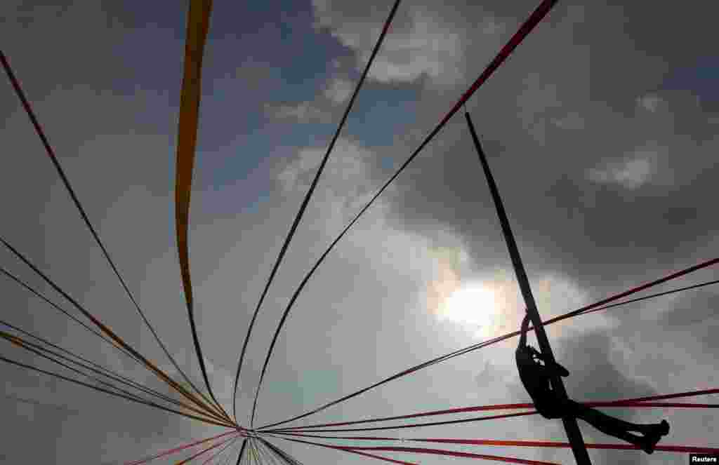 A man climbs up a greasy pole in a climbing competition as part of traditional festival games to celebrate Sinhala, Hindu and Tamil New Year in Colombo, Sri Lanka.