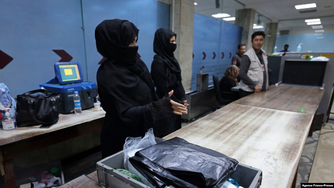 Afghan women airport workers are pictured at a security checkpoint in the airport in Kabul on Sept. 12, 2021.