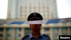 FILE - A police officer stands guard at the entrance to the Jinan Intermediate People's Court. While homosexuality is not illegal in China, same-sex marriage is not legal and same-sex couples do not have legal protections.