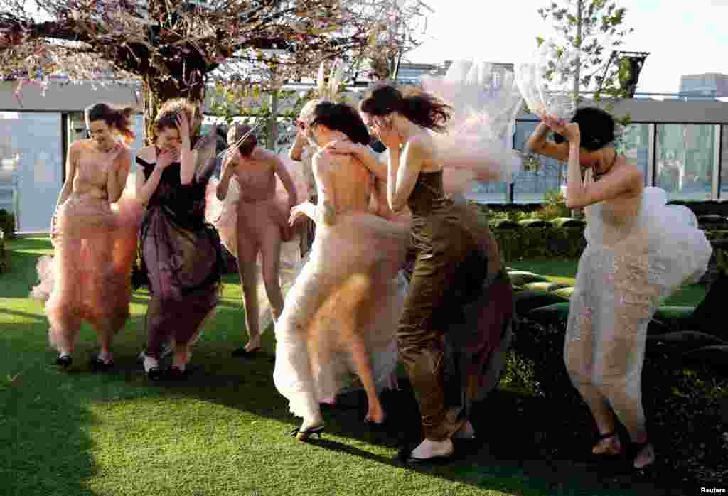 Models struggle against strong wind before the rehearsal of Christian Dior's Haute Couture Spring-Summer 2017 live show to celebrate Dior's new flagship store at the rooftop of Ginza Six mall in Tokyo, Japan.