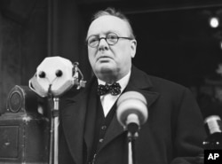 FILE - Winston Churchill approaches microphones to make a speech in January 1939. The British wartime leader played a principal role in drafting the European Convention on Human Rights.