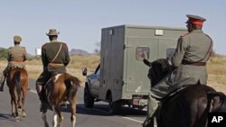 Riders on horse back escort the small truck that is transporting skulls of ancestors recently returned from Germany, from the airport to be put on display in the city of Windhoek, Namibia, October 4, 2011.