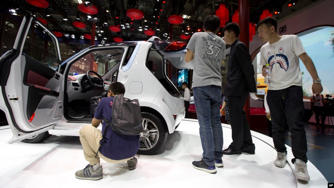Visitors to Auto China 2016 take a closer look at Zotye Auto's E200 electric vehicle displayed in Beijing, Apr. 25, 2016. 